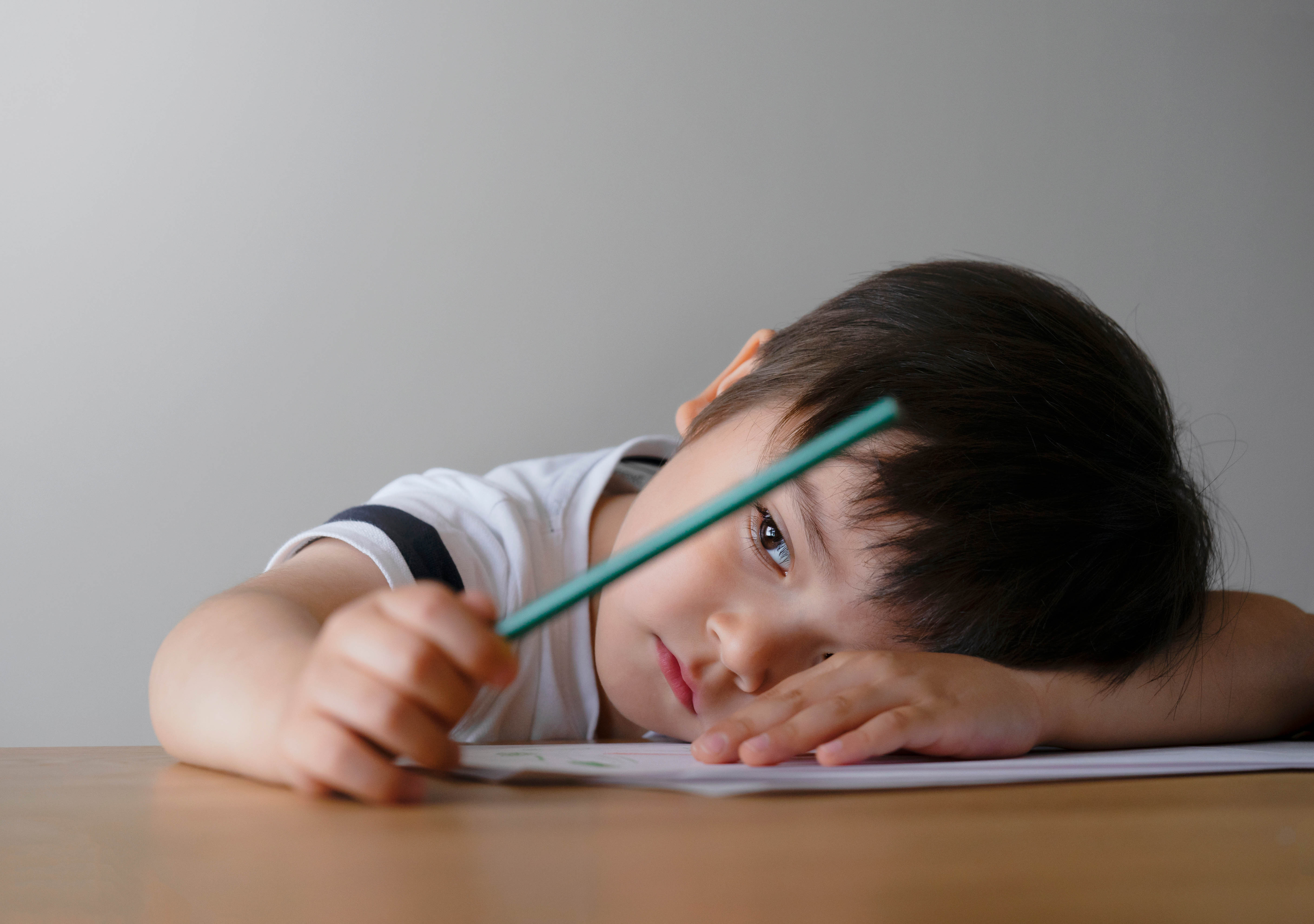 Young male student frustrated and struggling while staring at his homework